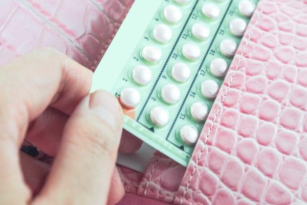 Why do women experience delayed periods after taking oral contraceptives?